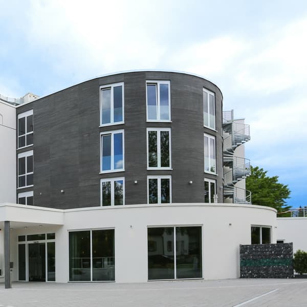 Fassadenverkleidung mit Sandsteintapete Ostrau einer runden Fassade an einem Neubau